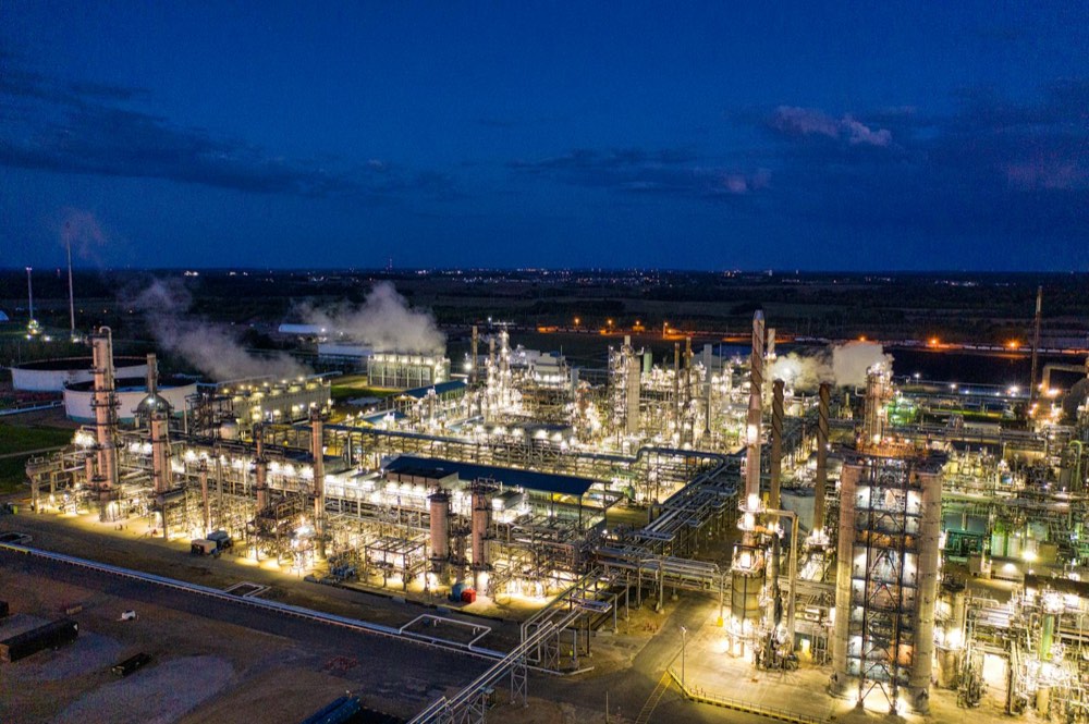 Refinaria industrial iluminada à noite